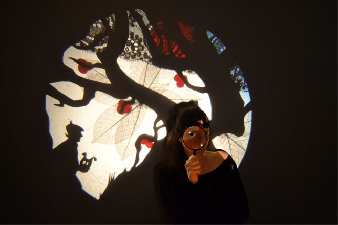 entresort en théâtre d'ombres arbre et personnage avec loupe